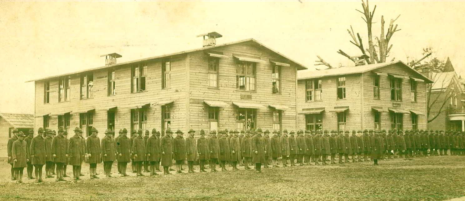 Soldiers on Ouachita’s campus in 1918. The men are standing where Cone-Bottoms Hall was later constructed. The president’s home can be seen at the far right.