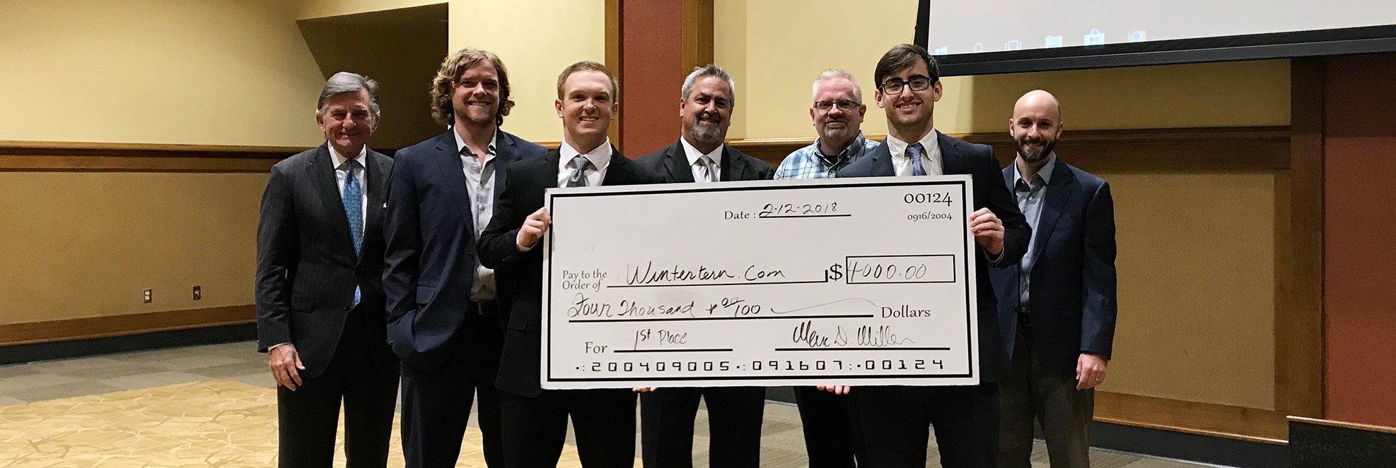 Chandler Blake (holding check, left) and Chris Clark (holding check, right) won first place in the 2018 OBU/HSU Business Plan Competition. They are joined by this year’s panel of judges.