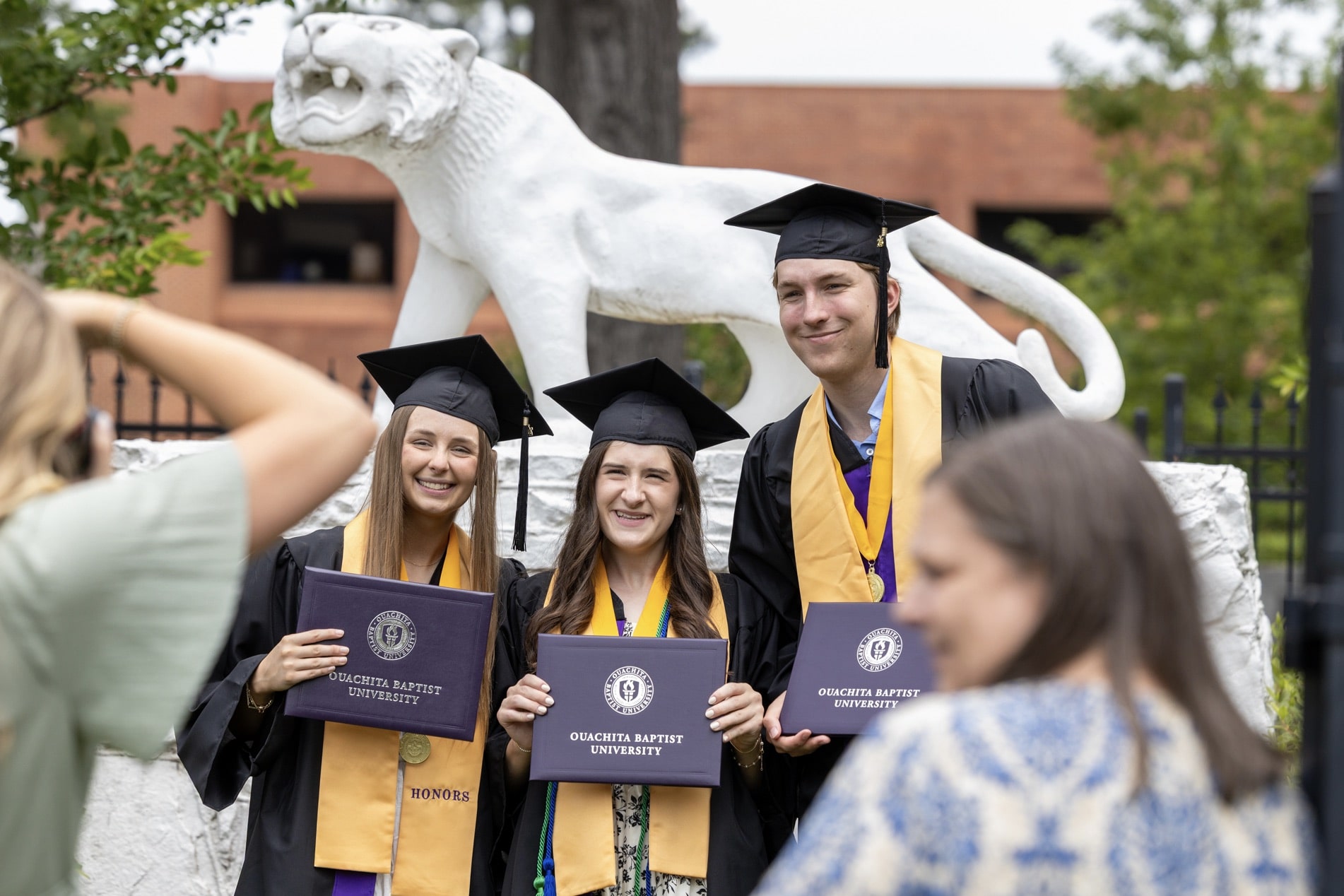 Graduates pose in front of the Tiger