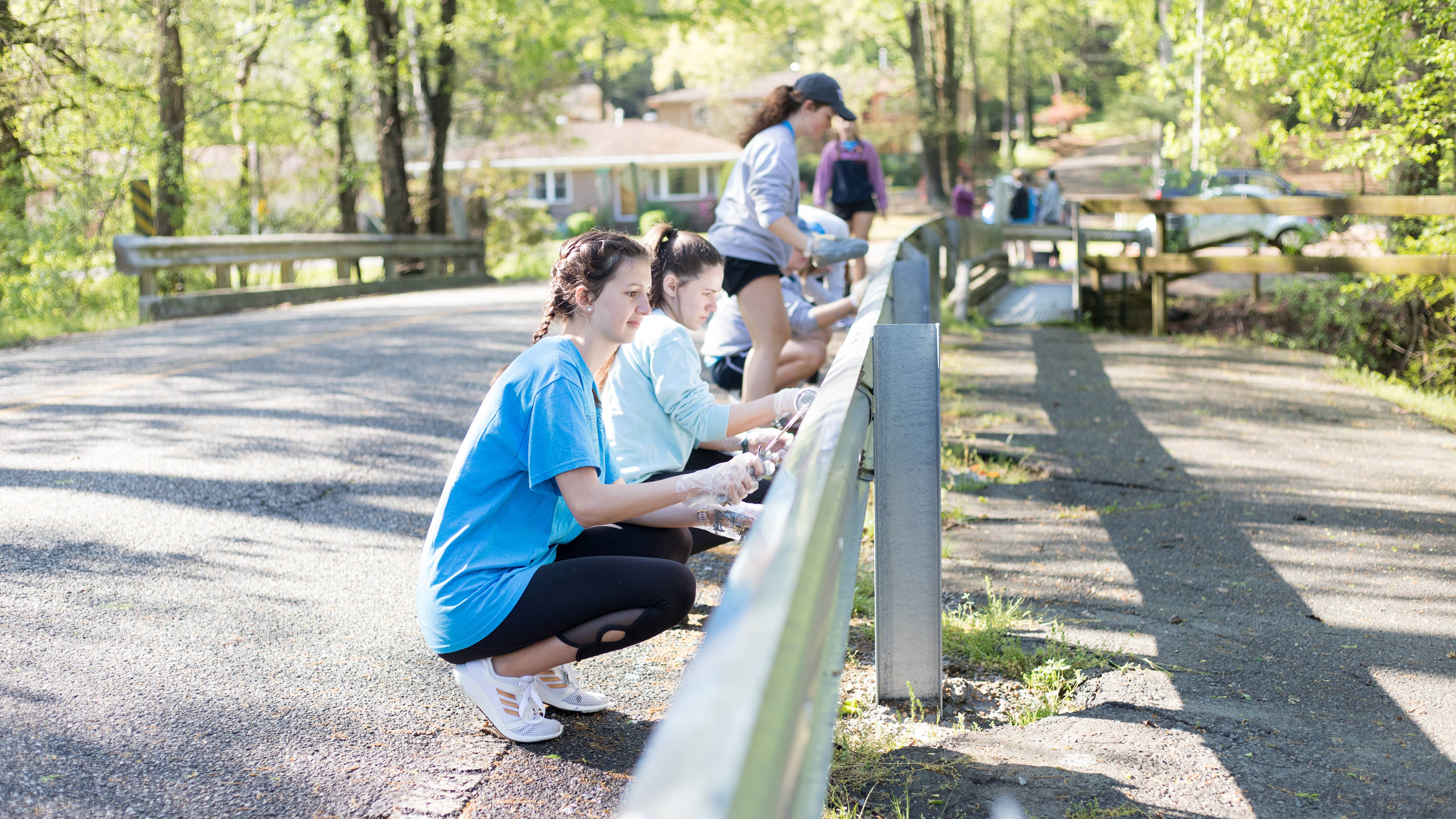 Students wash guard rails during spring Tiger Serve Day